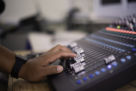 The DJ is adjusting the volume of the sound. Professional audio mixing consoleの写真素材