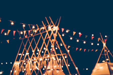 Blurred images of the background party in the festive festivities during the night, consisting of people and glittering bokeh.の写真素材