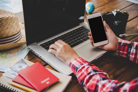 Travelers are planning a trip by searching the route on the map and searching for information on the internet.の写真素材