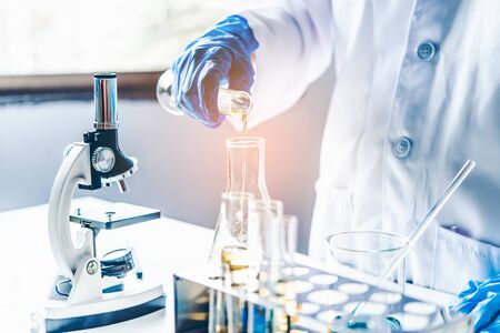  Equipment and science experiments oil pouring scientist with test tube yellow making research in...