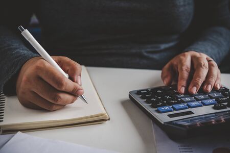 Businessman are working with a calculator and document. Meeting report in progress. in office business conceptの写真素材