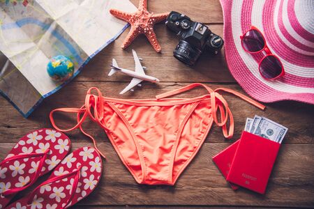 Beauty orange bikini and accessories on wooden floor for trip on summerの写真素材