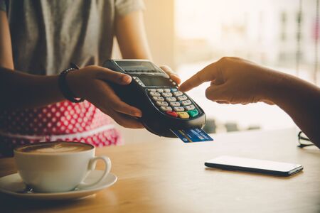 Close up of hand using credit card to pay by sending the credit card to the staff at the credit card...