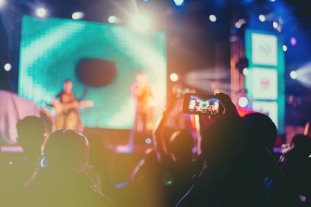 Fans are having fun, both taking pictures with the camera and mobile phone. Concert performerの写真素材