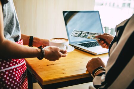 Customers pay by cash in the coffee shop.の写真素材