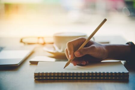 Closeup of woman's hand writing on paperの写真素材