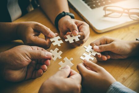 Business team handle a piece of white puzzles that are about to drop to get a complete worksheet - An attempt to succeed.の写真素材