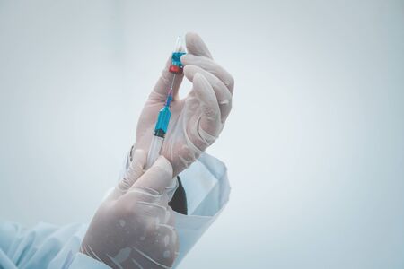 close-up doctor with syringe ready for injection of vaccine to patient. Vaccination concept.の写真素材