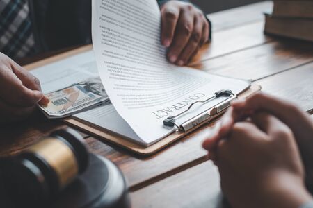 Businessmen accepting bribes for signing contracts. The concept of anti-corruption.の写真素材