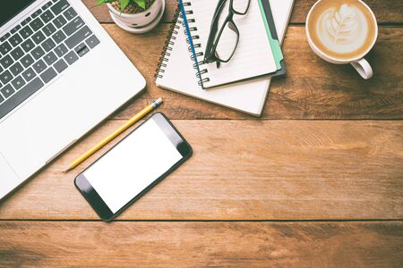 top view Office equipment including Laptop, mobile phone, mouse, notebook, coffee cup on the wood floorの写真素材