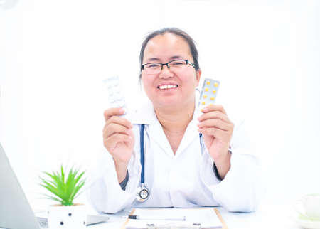Portrait of a female doctor on a white background giving knowledge about drug useの写真素材