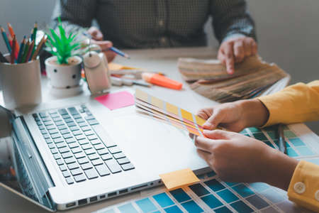 The graphic designer creative team is currently working on the design and color selection on the...