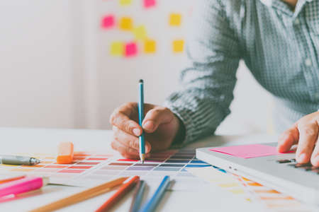 The graphic designer creative team is currently working on the design and color selection on the...
