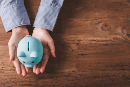 hand holding piggy bank, saving money and finance accounting concepts