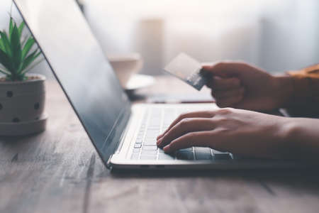 Women's hands holding a credit card and work on laptop Online payment for online shopping