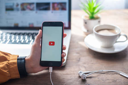 Lamphun, Thailand - June 21, 2020: In a hand for man with social networking service Youtube on the screen IPhone SE.YouTube is the popular online video sharing website.のeditorial素材