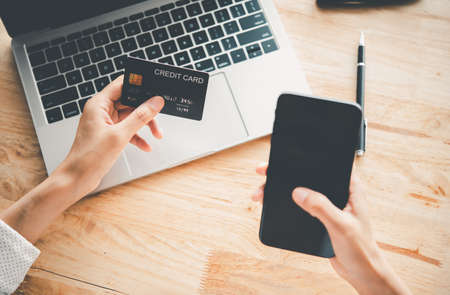 Women's hands holding a credit card and work on laptop Online payment for online shopping
