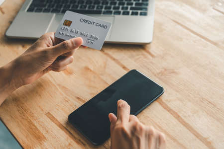 Women's hands holding a credit card and work on laptop Online payment for online shopping