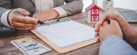 House signers signing signature loan document to home ownership with real estate agents ownership....