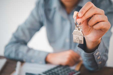 Salesperson Holding house keys concept, house keys for new house, new house purchaseの写真素材