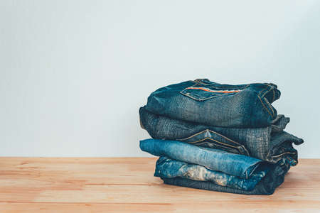 pile of jeans on a wooden backgroundの写真素材