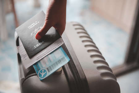 People holding passports and Coronavirus vaccination record card, map for travel with luggage for the trip. Covid-19 around the worldの写真素材