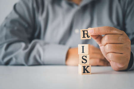 Hand hold wooden block with the word "RISK". Concept riskの写真素材