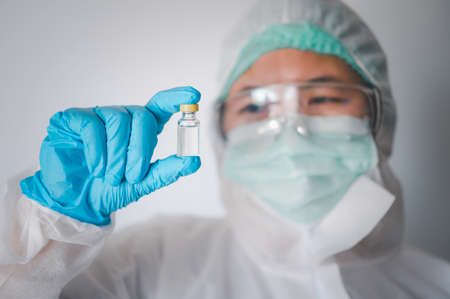 doctor or scientist holds a liquid vaccine bottle for the treatment of viral diseases.