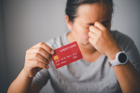 stressed woman with credit card due to inability to pay debts due to using the entire amount of...