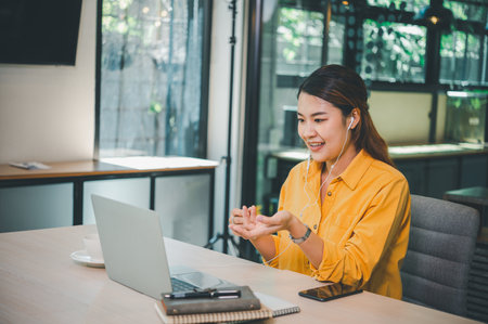 young student wearing headphones studies online, distance learning, and keeps up to date on the...