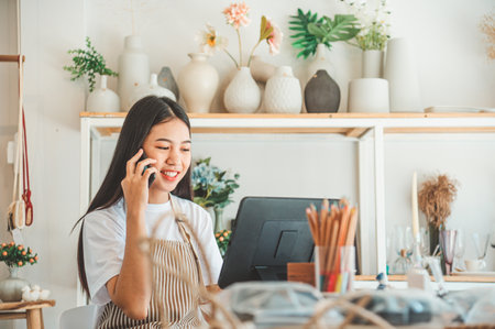 Small business owner talking on the phone with customers in a small shop. and check orders, check the orders that customers order from online retailers - online shoppingの写真素材
