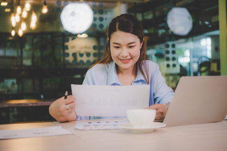 Asian business woman working using  laptop for do math finance on wooden desk, tax, accounting, statistics and analytical research conceptの写真素材