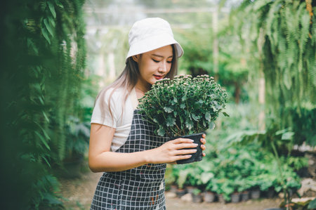 Young women doing hobbies taking care of plants, watering, shoveling flowers. In the garden during the break from workの写真素材