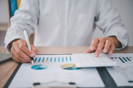 close up The business person is sitting on a calculator with a graph in the office of finance accounting conceptの写真素材