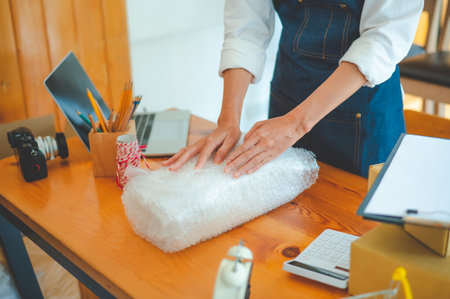Online small business owners are packing their ordered products into the boxes for their customers based on the concept of online shopping - online shopping.の写真素材