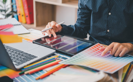 Graphic designer architects who work with laptops and color comparison tables for design work.の写真素材