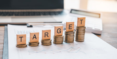 wooden block with the words TARGET on coin.concept the goal of collecting money.