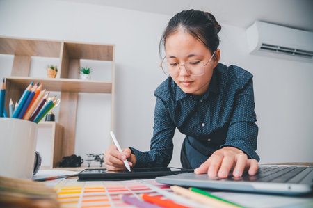 Graphic designer architects who work with laptops and color comparison tables for design work.の写真素材