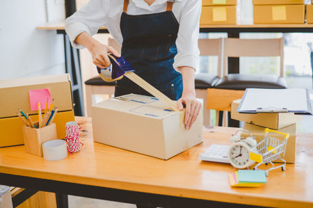 Online small business owners are packing their ordered products into the boxes for their customers based on the concept of online shopping - online shopping.の写真素材