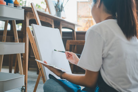 Art student drawing with watercolor painting on canvas doing some art projects on studio workshopの写真素材