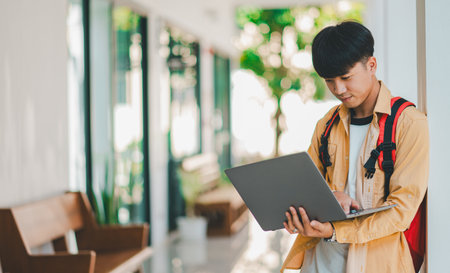 Happy smiling student with book in hand on campus while going to study for learning.の写真素材
