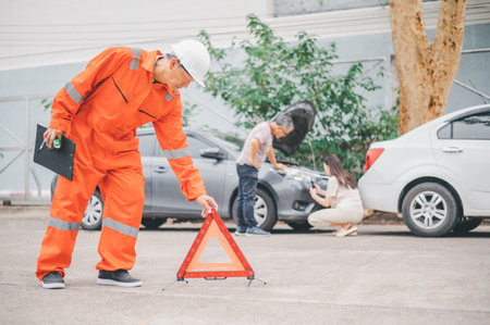 Insurance officers hold a red emergency triangle sign on the road to indicate that there is an...