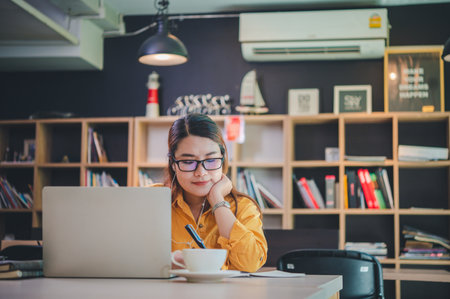 business woman sits working online on a laptop computer in a cafe.の写真素材