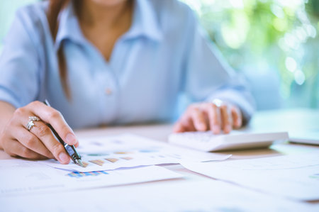 Business asian woman sitting at a desk at an office By using the calculator to work. Business Concept Analysis and Planningの写真素材