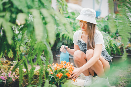 Young women doing hobbies taking care of plants, watering, shoveling flowers. In the garden during the break from workの写真素材
