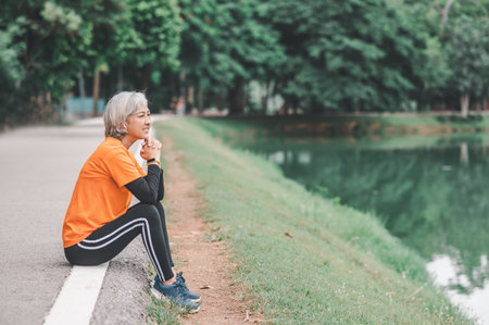 Elderly woman exercising in the park early in the morning.の写真素材