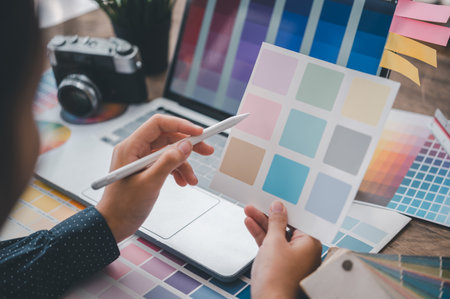 Graphic designer architects who work with laptops and color comparison tables for design work.の写真素材