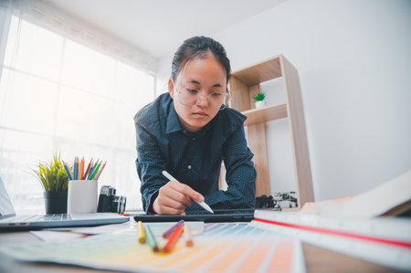 Graphic designer architects who work with laptops and color comparison tables for design work.の写真素材