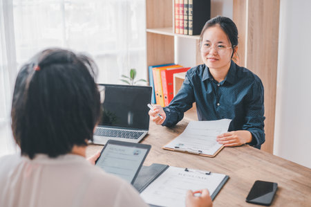 HR managers are interviewing job applicants who fill out their resume on the job application form in order to consider accepting a job as a companyの写真素材