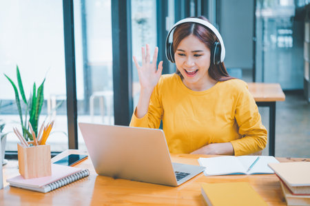 young student wearing headphones studies online, distance learning, and keeps up to date on the global coronavirus pandemic.の写真素材